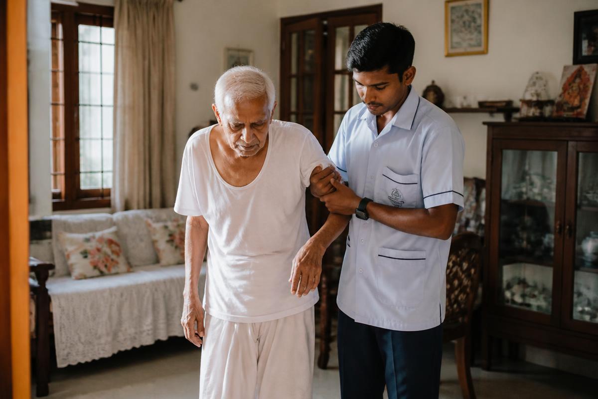 Attendant helping a frail elderly cancer patient walk across the living room